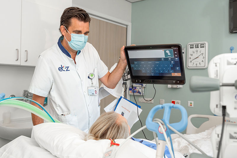 IC-verpleegkundige Arné van Hees maakt een patiënt vertrouwd met het systeem voor oogbesturing. FOTO: ETZ/Ellen den Ouden