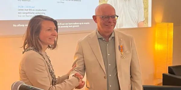 De Tilburgse loco-burgemeester Evelien Kostermans feliciteert prof. dr. Leo Visser met zijn koninklijke onderscheiding.