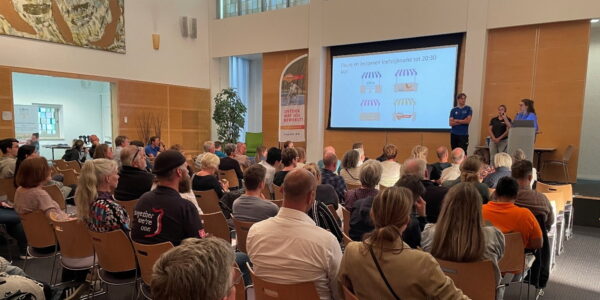 Aanwezigen van de leefstijlavond voor mensen met MS luisteren naar een presentatie.